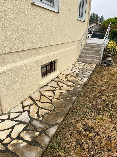 Allée en dallage le long d'une maison avant nettoyage